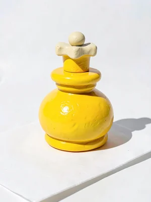 Compact chunky clay chess king in primary yellow with stubby cream-toned cross t