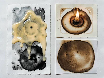A chemigram with wax resist — candle-wax dragged across paper, chemical zones is