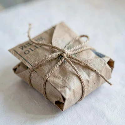 Folded brown craft paper formed into a tied newspaper bundle, soft fiber close-u