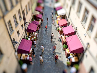 Midmorning tilt-shift photograph from a church spire of a market street, saturat
