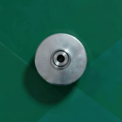 single brushed-aluminium docking-station hub top-down on a deep emerald backdrop