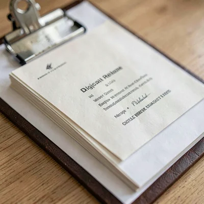 Macro of a stack of digital release proofs on a clipboard, paper fiber grain