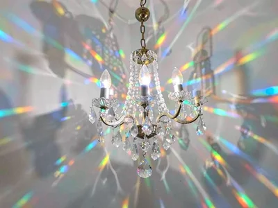 Chandelier crystal creating spectrum scatter on wall