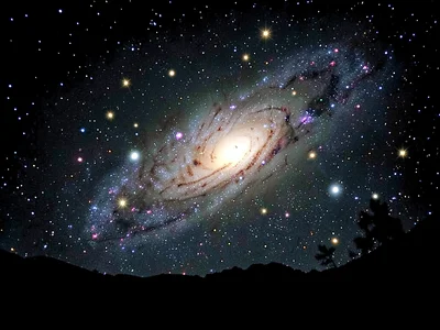 Galaxy silhouette against brighter background cluster