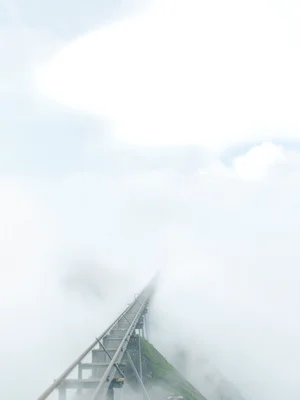 Steep funicular line climbing into cloud, lower tracks visible, upper terminal e