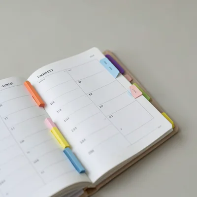 Close-up of a planner open to a weekly spread with colorful tabs