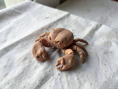 Ribby terracotta crab with thumb-pressed claws and fingernail-segmented legs, on