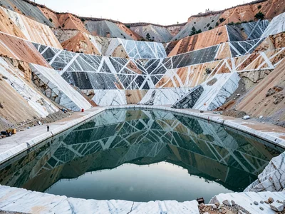 Quarry pool perfectly reflecting cut walls above