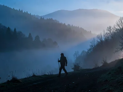 Early worker walking into fog becoming silhouette