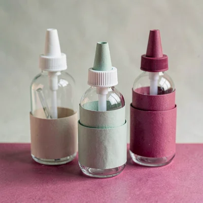 Papercraft composition of layered paper-cut acrylic squeeze bottles, soft sage a