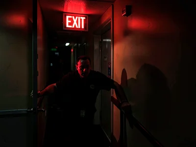 Person sneaking out of conference, EXIT sign guiding the escape from boredom