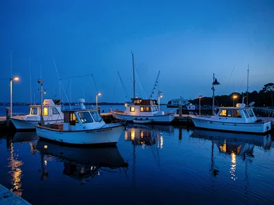 Harbor boats with cabin lights in blue hour