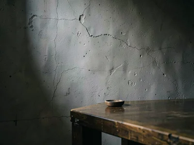 Table corner at bottom edge with single object barely on surface