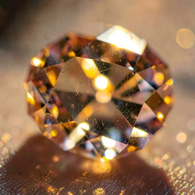 Tight macro of a faceted citrine catching deep amber light through its facets