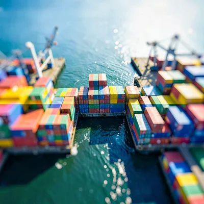 Top-down tilt-shift photograph from drone height of a container harbor at noon, 