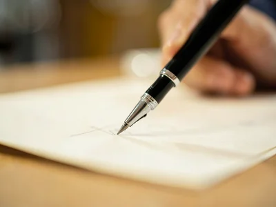 Pen tip writing on paper, desk dissolved