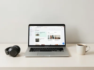 Open laptop with online course interface, headphones and coffee on desk