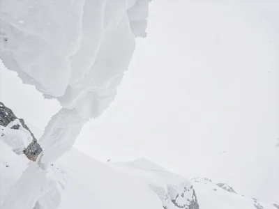 Snow cornice overhang against white sky