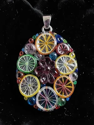Finished millefiori pendant on black velvet — oval shape, flower cross-sections 