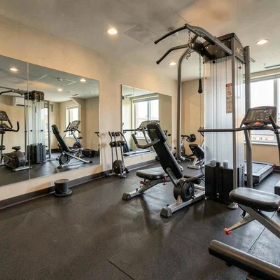 fitness room of an apartment community with mirrors and equipment
