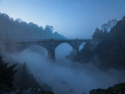 Bridge arches partially visible above and below fog layer