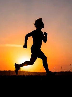 Runner silhouetted against sunrise