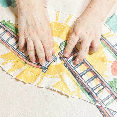 Small hands joining two track sections on a sunny carpet