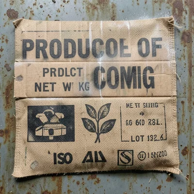 A burlap coffee sack with stenciled text reading PRODUCT OF COLOMBIA, NET WT 60 