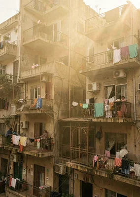 Dusty golden Cairo haze compressing apartment layers, old elevator cage in apart