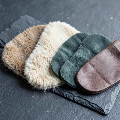 Material swatch study of three earpad materials fanned on slate, lambskin, micro