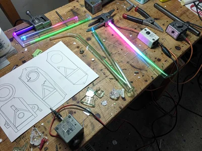 Overhead view of a workbench with tube templates, benders, and glass scraps