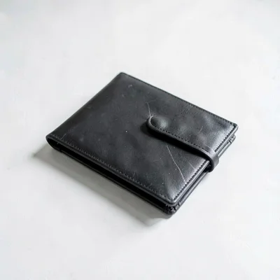 White-on-white still of a closed leather portfolio resting on a chalk desk, hair