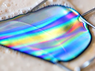 Extreme closeup of soap film thickness transition zone, sharp boundary between b