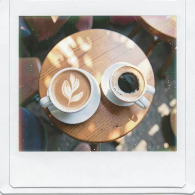 Expired Polaroid instant film photograph, Two coffee cups on small cafe table, v