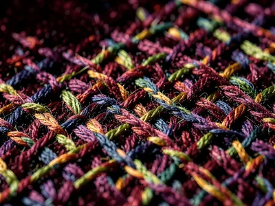 Velvet pile under side lighting, forest of cut fiber loops casting tiny shadows,