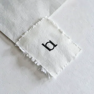 Vertical detail of a single letter slipped into a paper sleeve, edge feathered