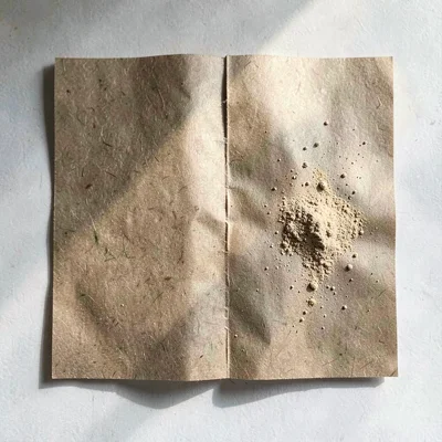 Quarter-folded brown butcher paper square with a deep press-line down the middle
