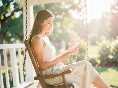 A woman reading on a porch swing in summer afternoon