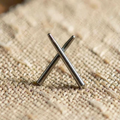 Macro of two hook tips crossing on a textured fabric