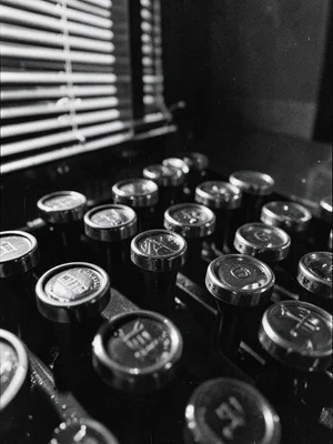 Row of typewriter keys from low angle, circular glass caps with metal rings