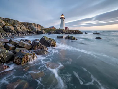 Lighthouse on rocks surrounded by cotton water