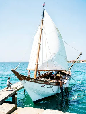 Brilliant Indian Ocean noon light in Dar es Salaam, Dhow being painted, workers 