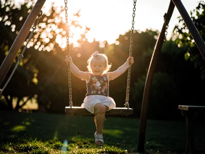 Child on swing backlit