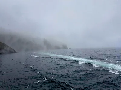 Ferry wake disappearing into mist distance