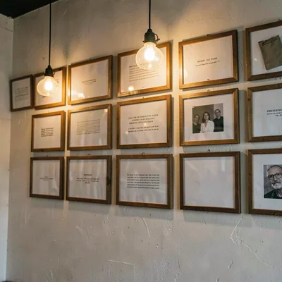 Atmospheric crop of an artist's wall covered in framed flash sheets (no readable