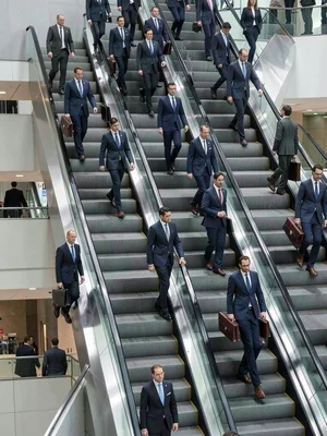 Parallel escalators compressed into infinite regression, identical business suit