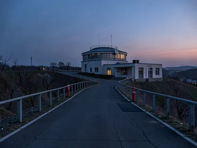 Observatory access road ascending toward twilight
