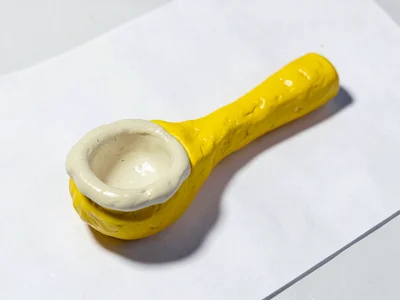 Rustic chunky clay wooden spoon in primary yellow with stubby cream-toned bowl a