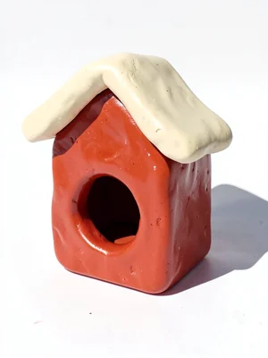 Rustic chunky clay birdhouse in cherry red with stubby cream-toned roof and over