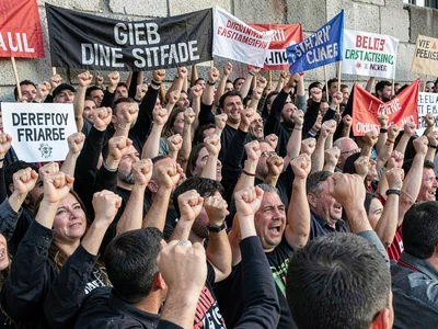 Political demonstration compressed into wall of raised fists and banners, indivi